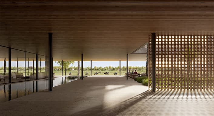 Clubhouse lounge interior at Grand Polo Club & Resort, with the polo fields visible beyond