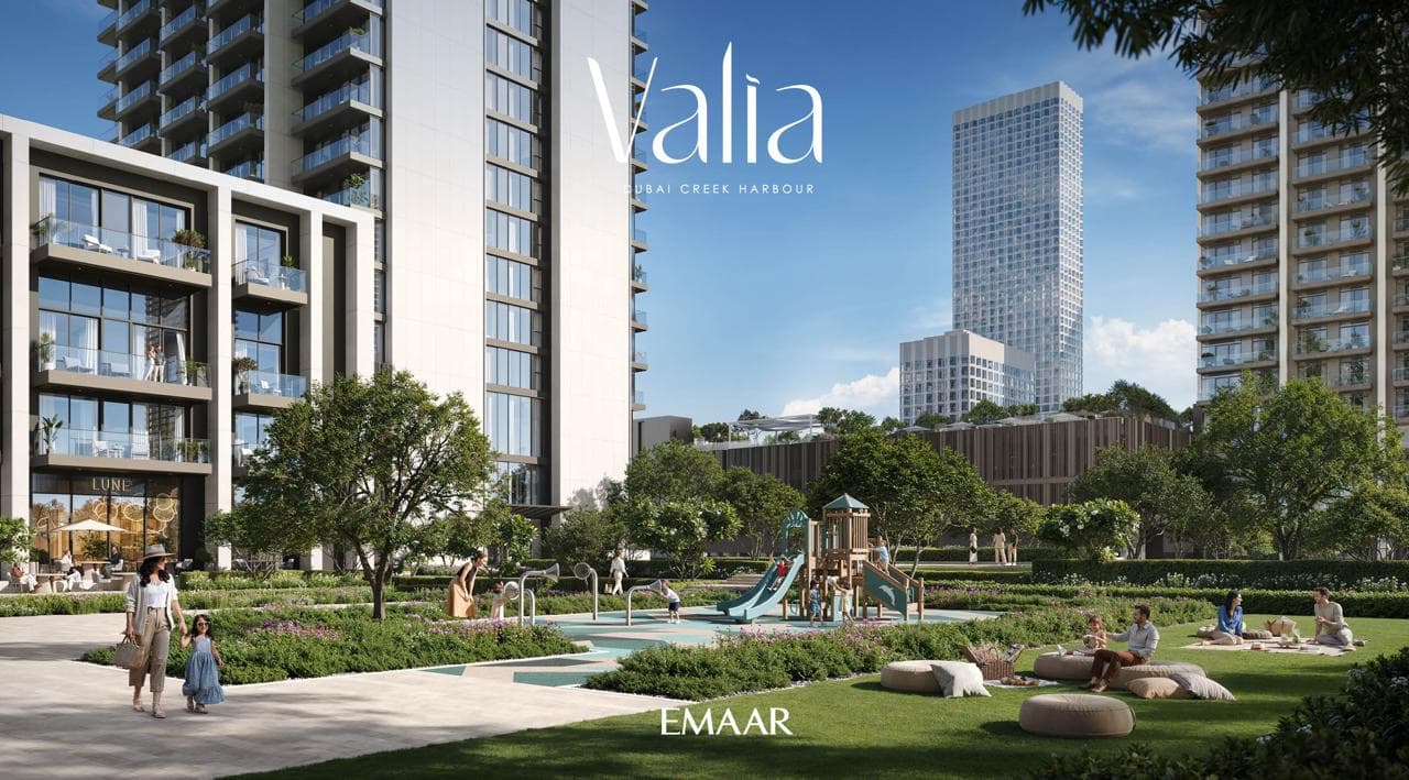 Landscaped garden and children's playground at the base of Valia, with a future landmark tower visible beyond the podium