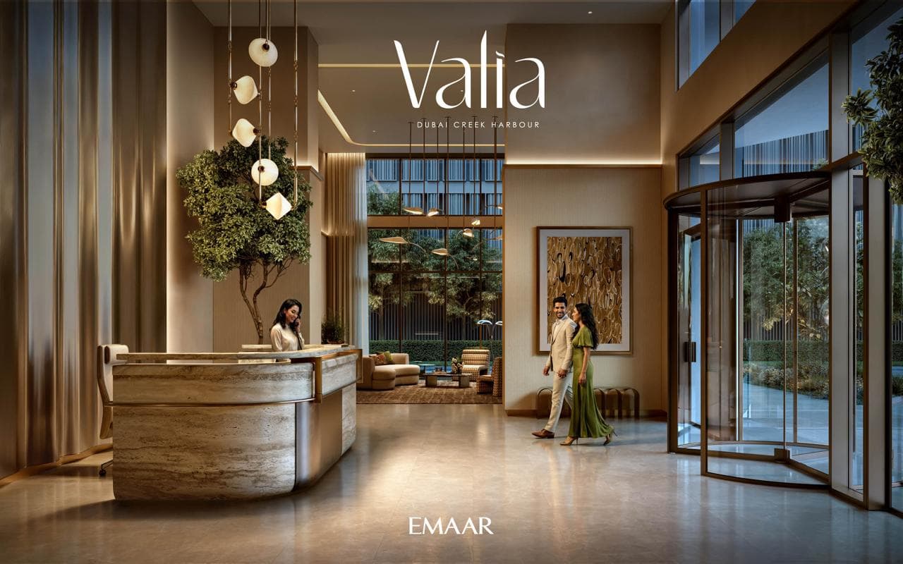 Valia's double-height residential lobby with a concierge desk and a revolving entrance door