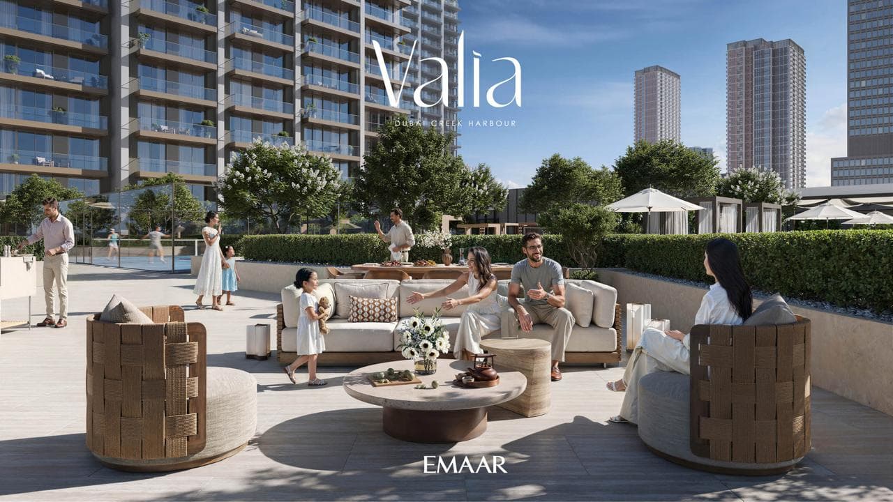 Residents relaxing and dining on a landscaped terrace outside Valia's podium, city skyline behind